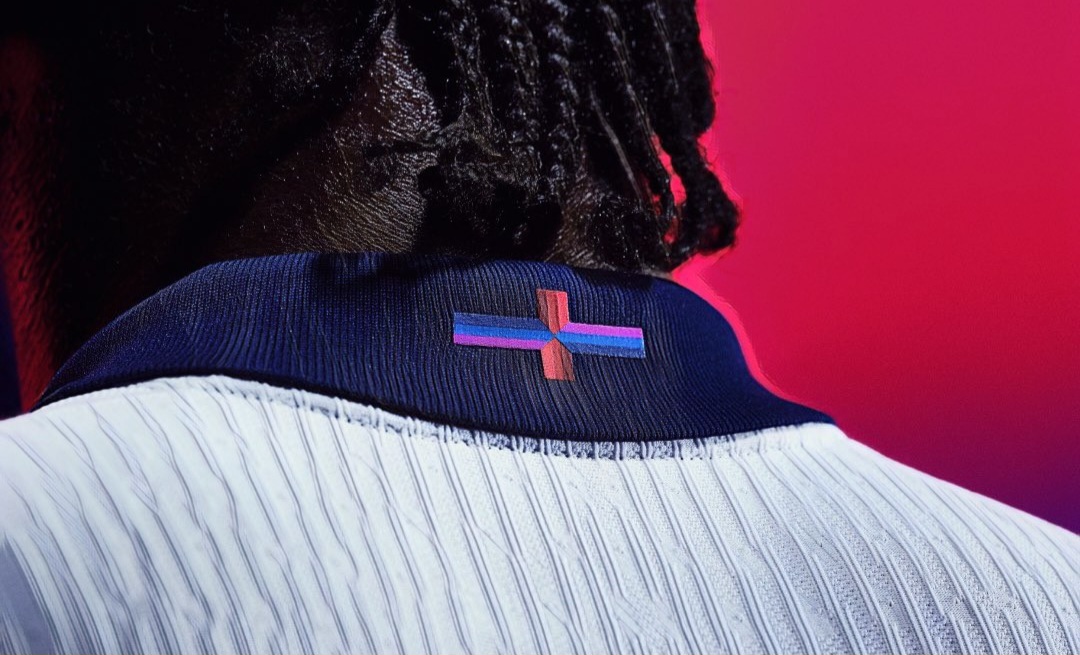 The new England kit by Nike features a multicoloured cross.