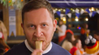 A Scotland fan bites down on a hot dog during IRN BRU's football ad ahead of Euro 2024.