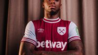 Aaron Wan-Bissaka poses in a West Ham United jersey following his transfer from Man Utd.