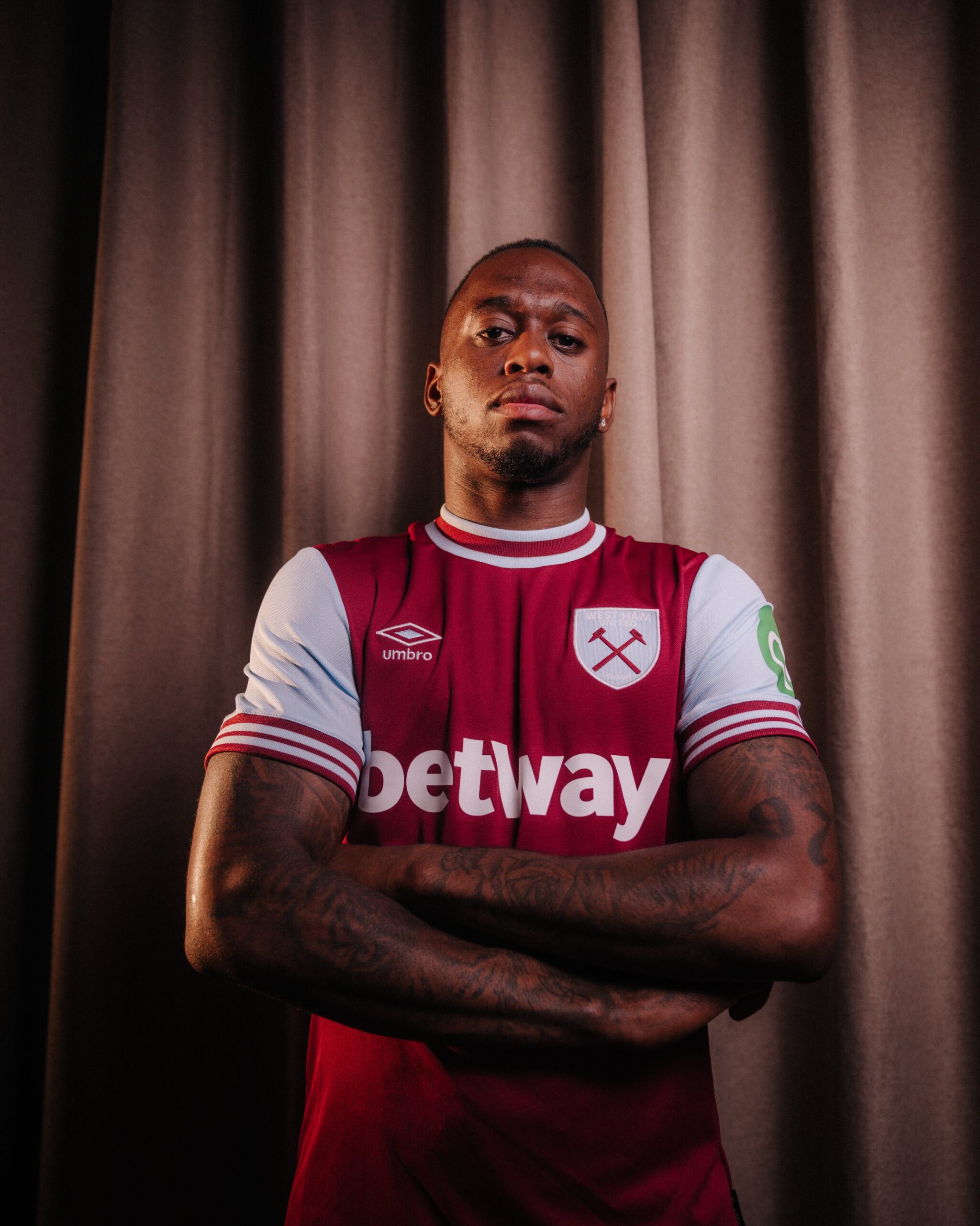 Aaron Wan-Bissaka poses in a West Ham United jersey following his transfer from Man Utd.